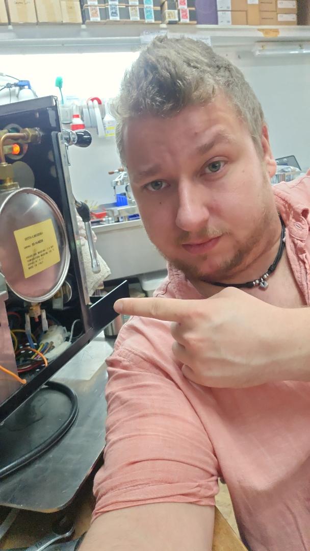 Maximilian Sebastian Kunz neben einer geöffneten Kaffeemaschine in der Werkstatt